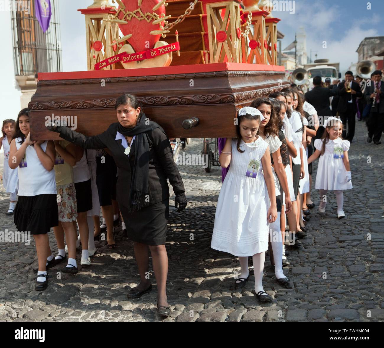 Antigua, Guatemala. Semana Santa (settimana Santa). Le ragazze giovani portano un'Anda (float) in una processione religiosa. Foto Stock