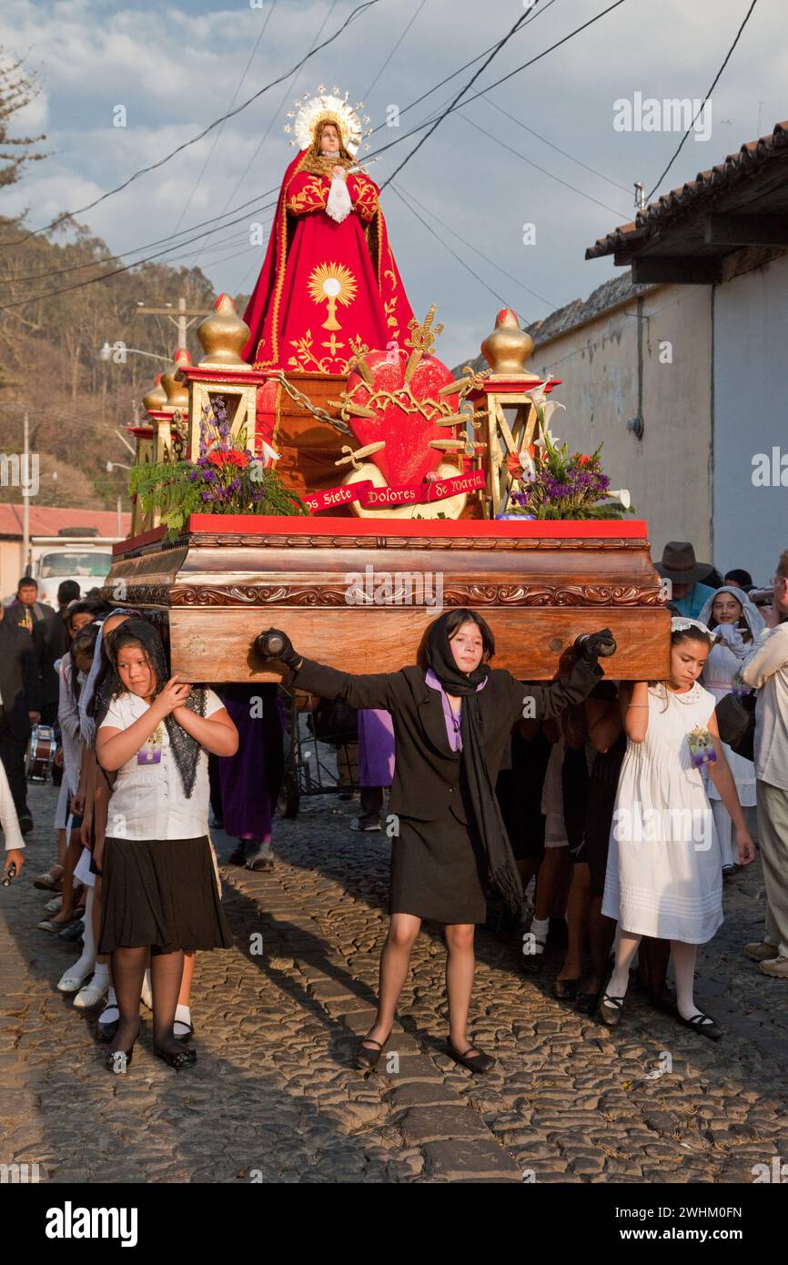 Antigua, Guatemala. Semana Santa (settimana Santa). Giovani ragazze che portano un'Anda (float) della Vergine Maria in una processione religiosa. Foto Stock
