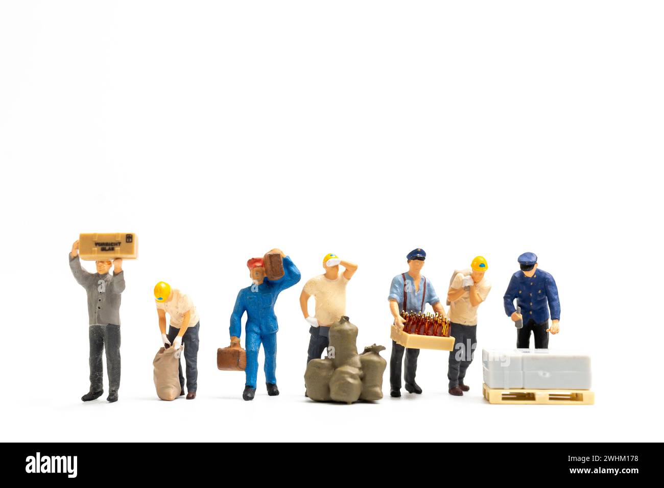 Miniature People, team di lavoro in piedi su sfondo bianco, concetto di giornata del lavoro Foto Stock