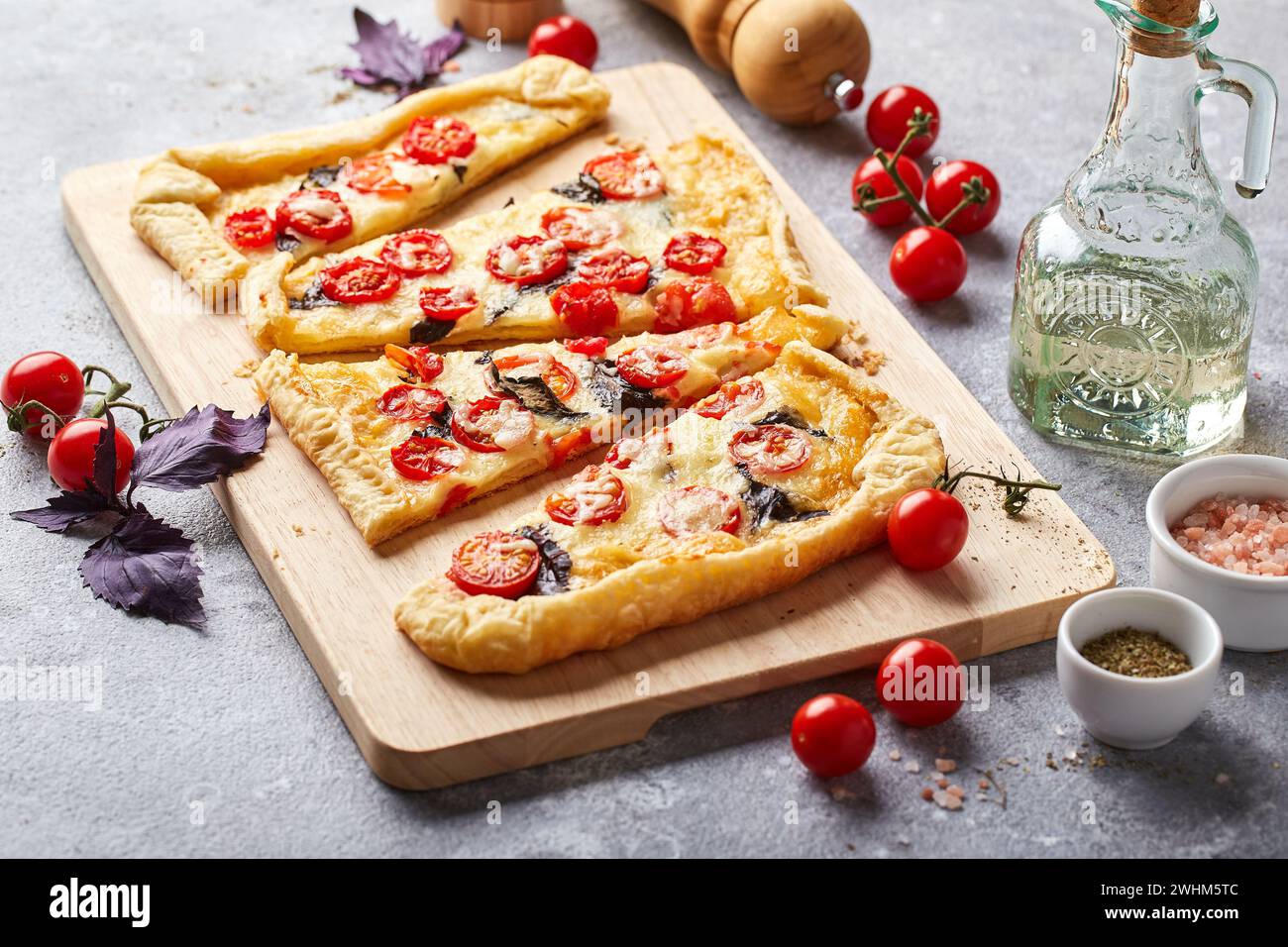 Torta di pasta sfoglia con pomodori ciliegini, mozzarella e basilico viola Foto Stock