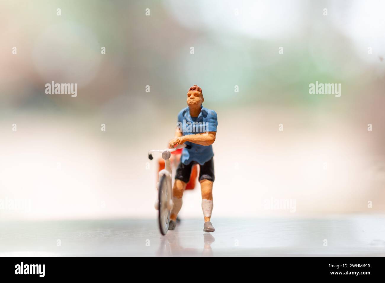 Ciclista in miniatura in piedi con la bicicletta, concetto di giornata mondiale della bicicletta Foto Stock
