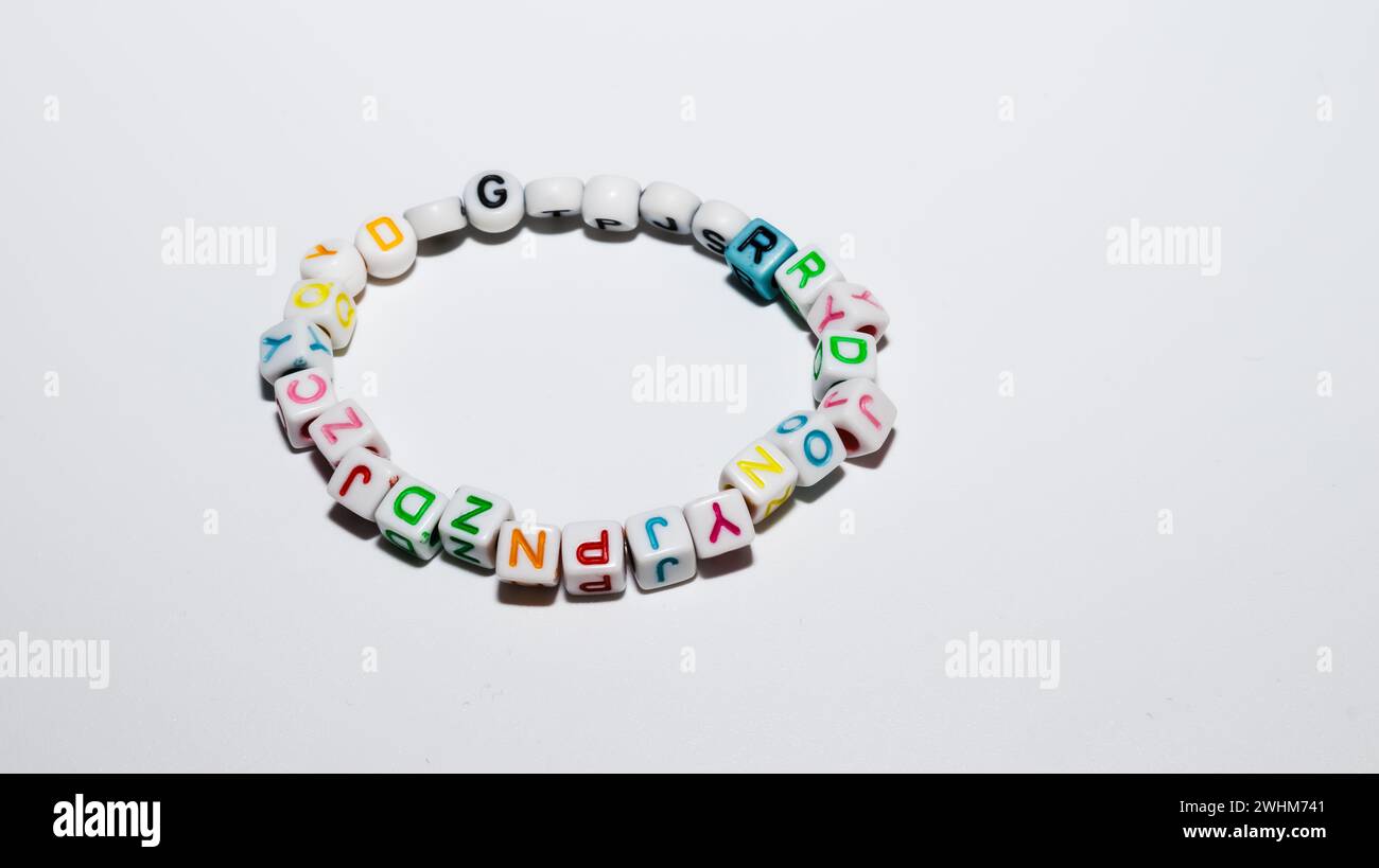 Bracciale in plastica colorata isolato su sfondo bianco. Braccialetto colorato per bambini con lettera d'amore e perline isolate. Foto di alta qualità Foto Stock