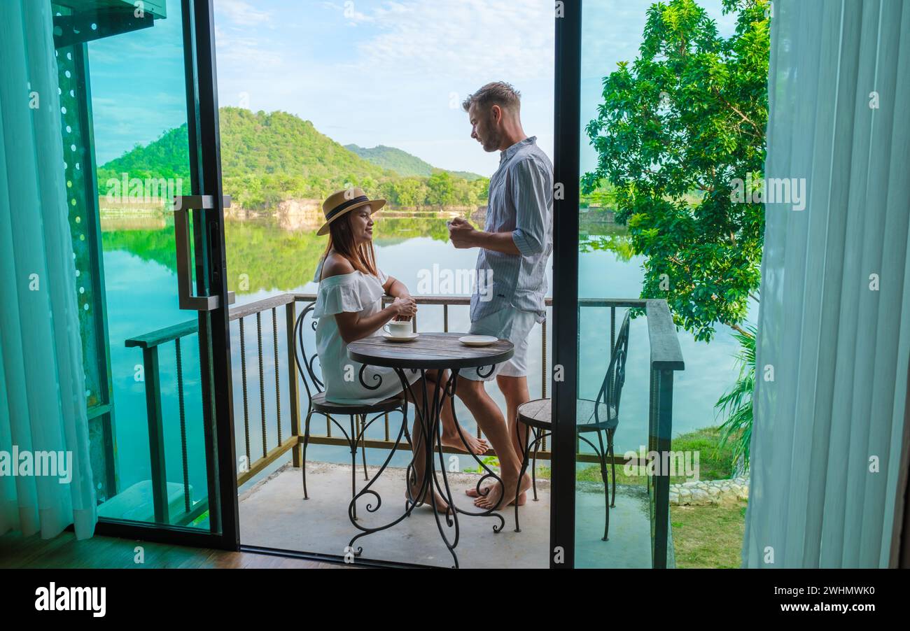 Una coppia in vacanza in Thailandia bevendo un caffè la mattina sul balcone Foto Stock