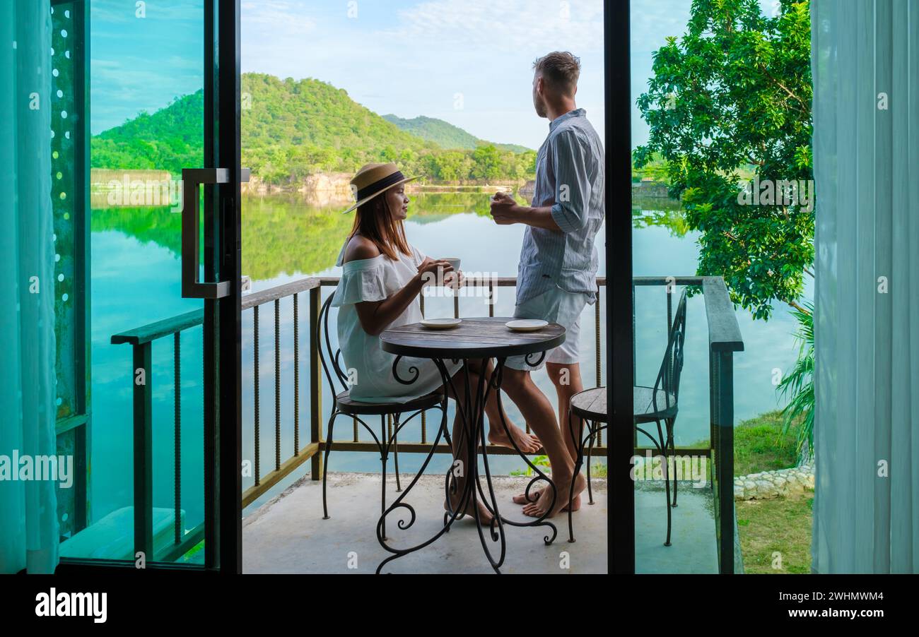 Una coppia in vacanza in Thailandia bevendo un caffè la mattina sul balcone Foto Stock
