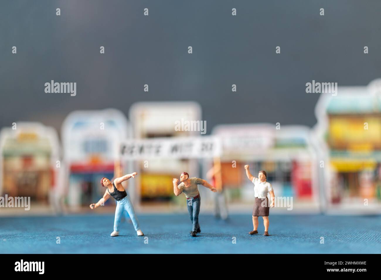 Persone in miniatura, manifestanti che tengono i cartelli, alzano le mani Foto Stock