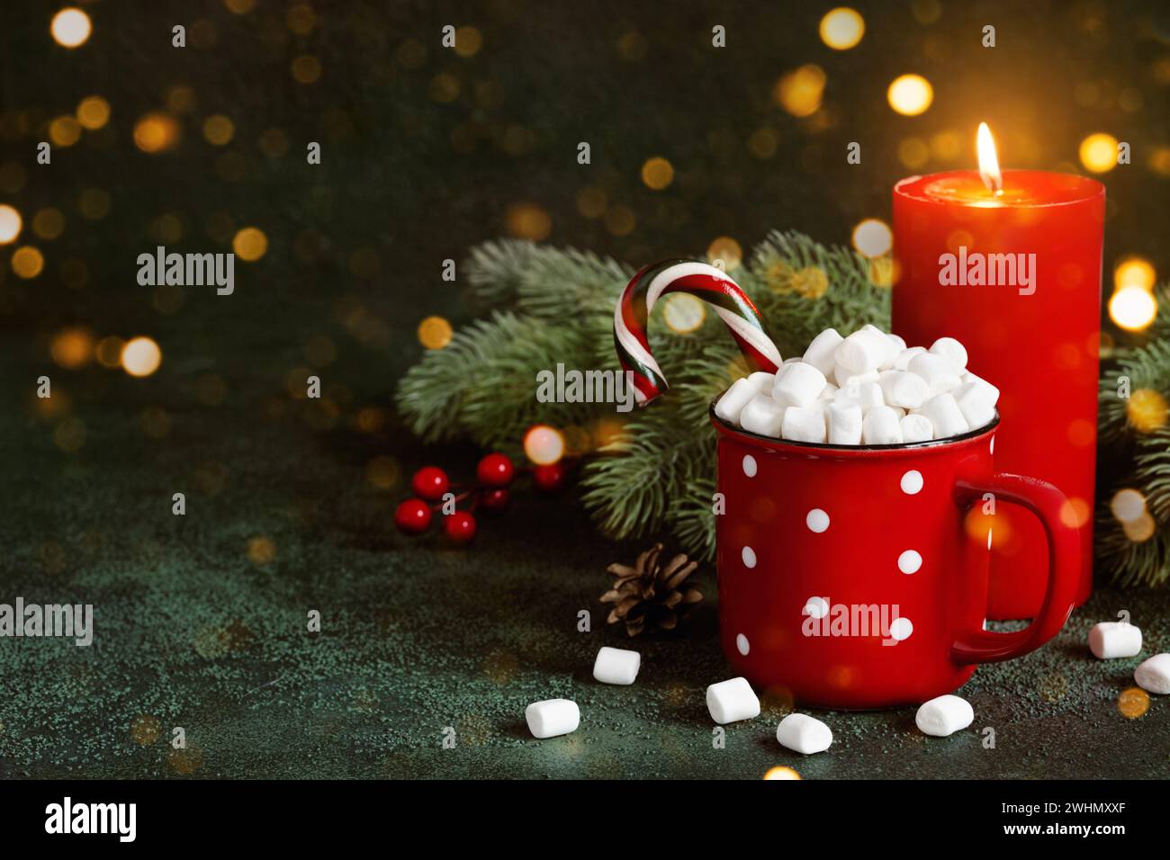 Drink di Natale o Capodanno. Tazza rossa con cioccolata calda e marshmallow su sfondo brillante, copia spazio Foto Stock