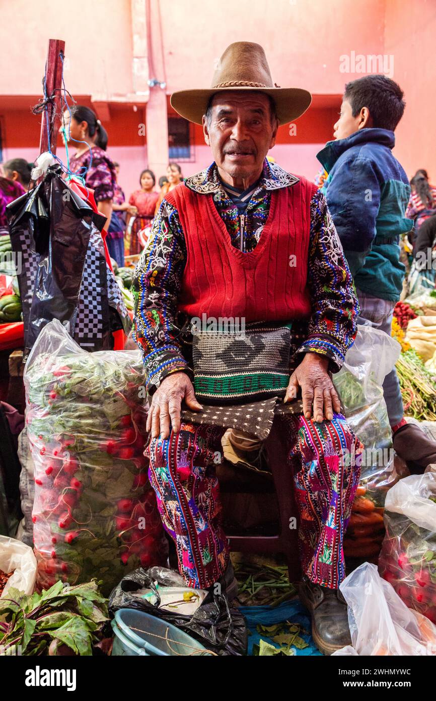 Chichicastenango, Guatemala. Quiche (Kiche, K'iche') uomo che indossa ricamato camicia e pantaloni, nel mercato coperto, la domenica mattina. Foto Stock