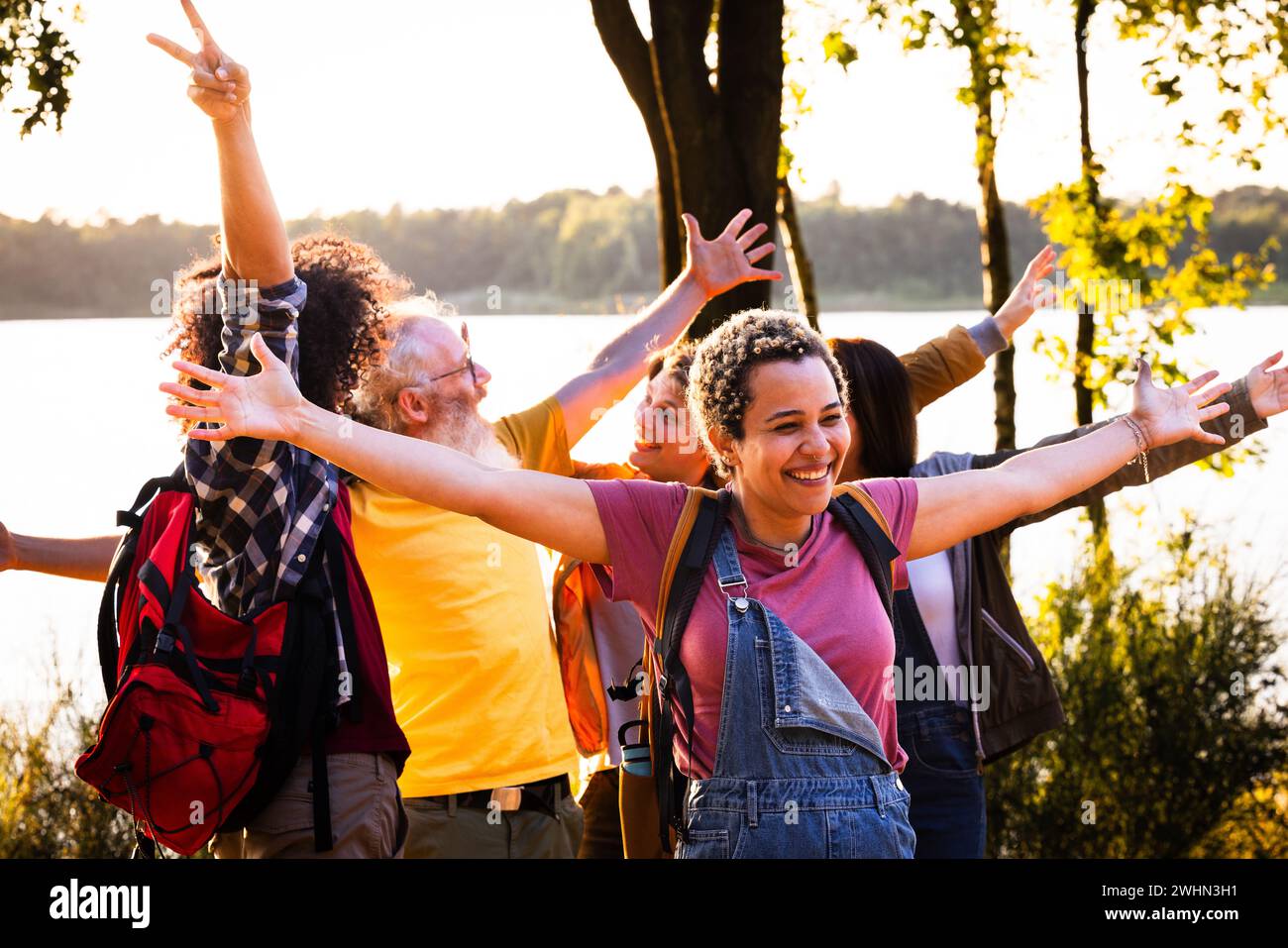 Gruppo di giovani amici multirazziali felici che si divertono insieme godendosi le vacanze estive sul lago della foresta, Focus su Young Bra Foto Stock