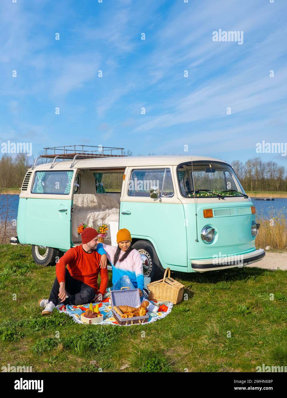 Coppia che fa un viaggio su strada con una vecchia auto d'epoca nella regione olandese dei fiori con campi di tulipani Foto Stock Coppia che fa un viaggio su strada con una vecchia auto d'epoca nella regione olandese dei fiori con campi di tulipani Foto Stock