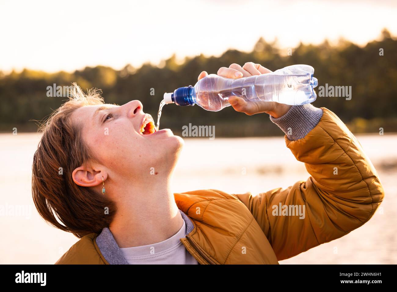 Momento rinfrescante: Giovane ragazza caucasica assaporando l'acqua all'aperto Foto Stock