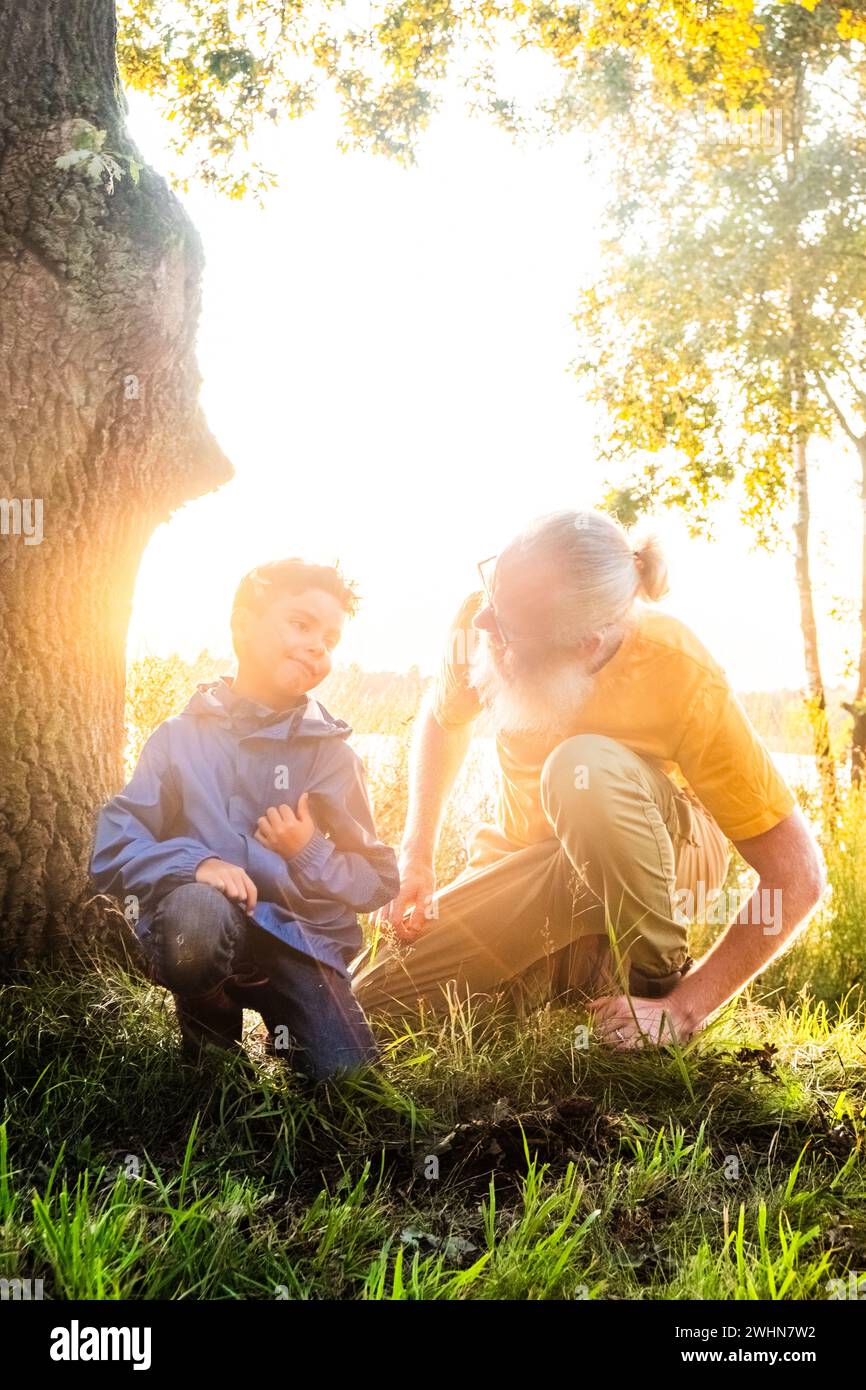 Padre-figlio Bond: Esplorare le meraviglie della natura al tramonto Foto Stock