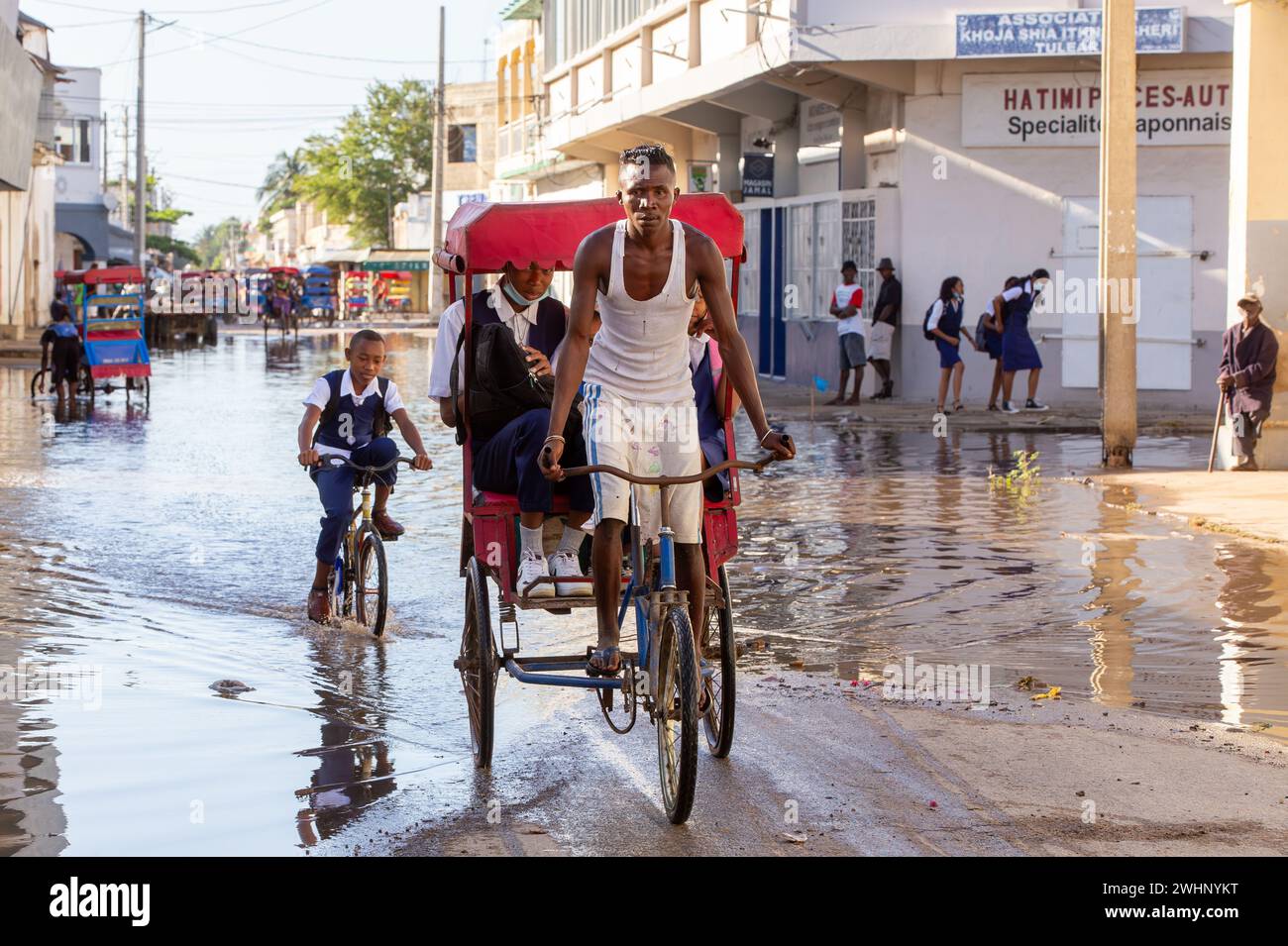 Bicicletta tradizionale risciò con gente malgascia sulla strada di Toliara, uno dei modi per guadagnare soldi. La vita quotidiana sul Foto Stock