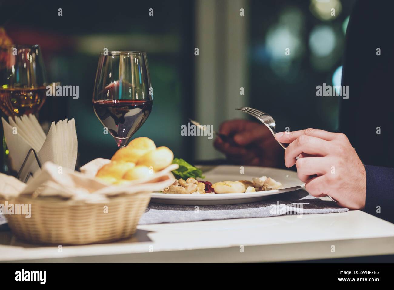 Mani d'uomo che mangiano ottimi piatti di alta cucina al tavolo del ristorante Foto Stock