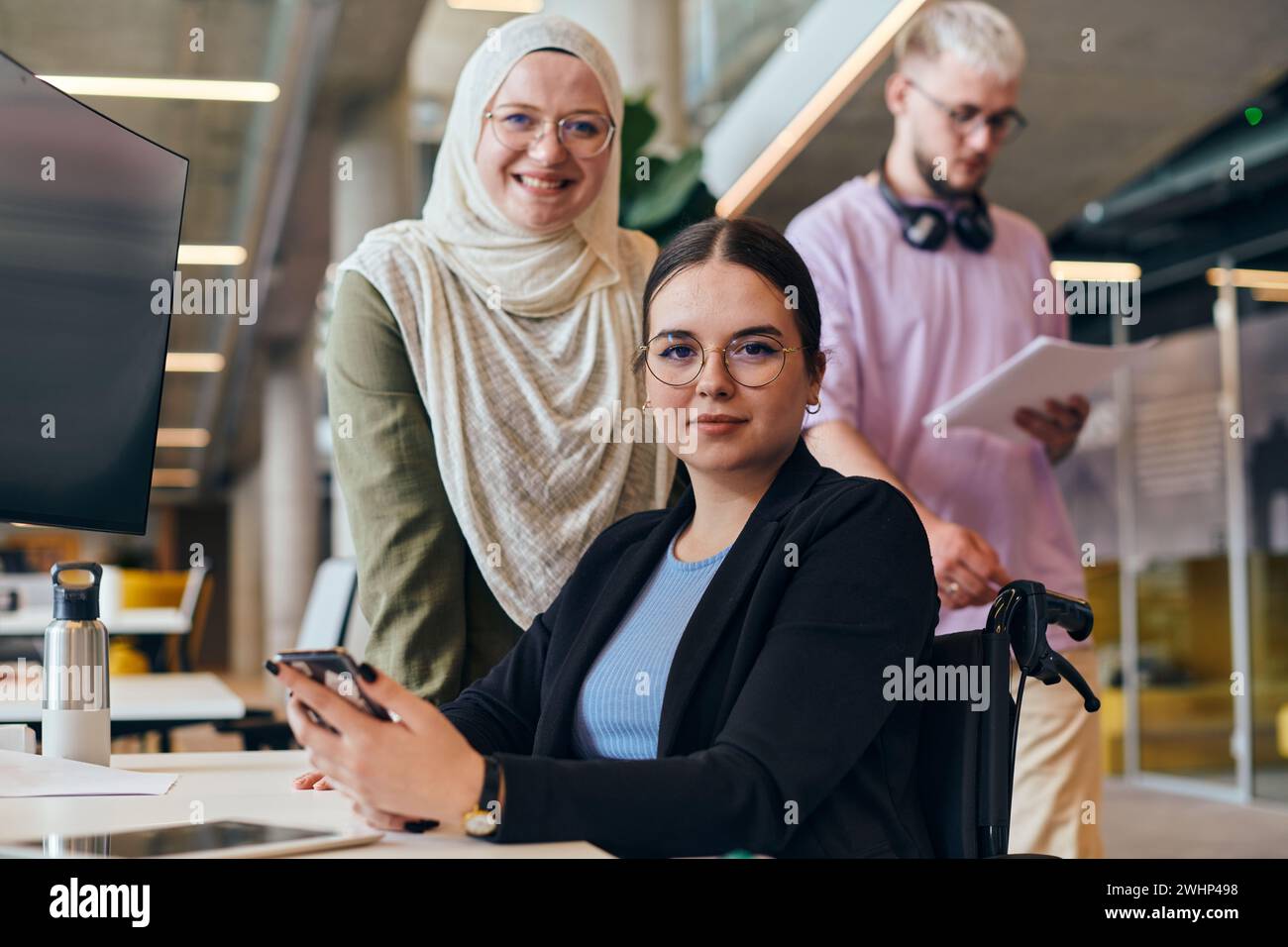 In una startup moderna vivace e variegata, un gruppo di donne d'affari contemporanee, tra cui una che indossa un hijab, si riuniscono, ex Foto Stock