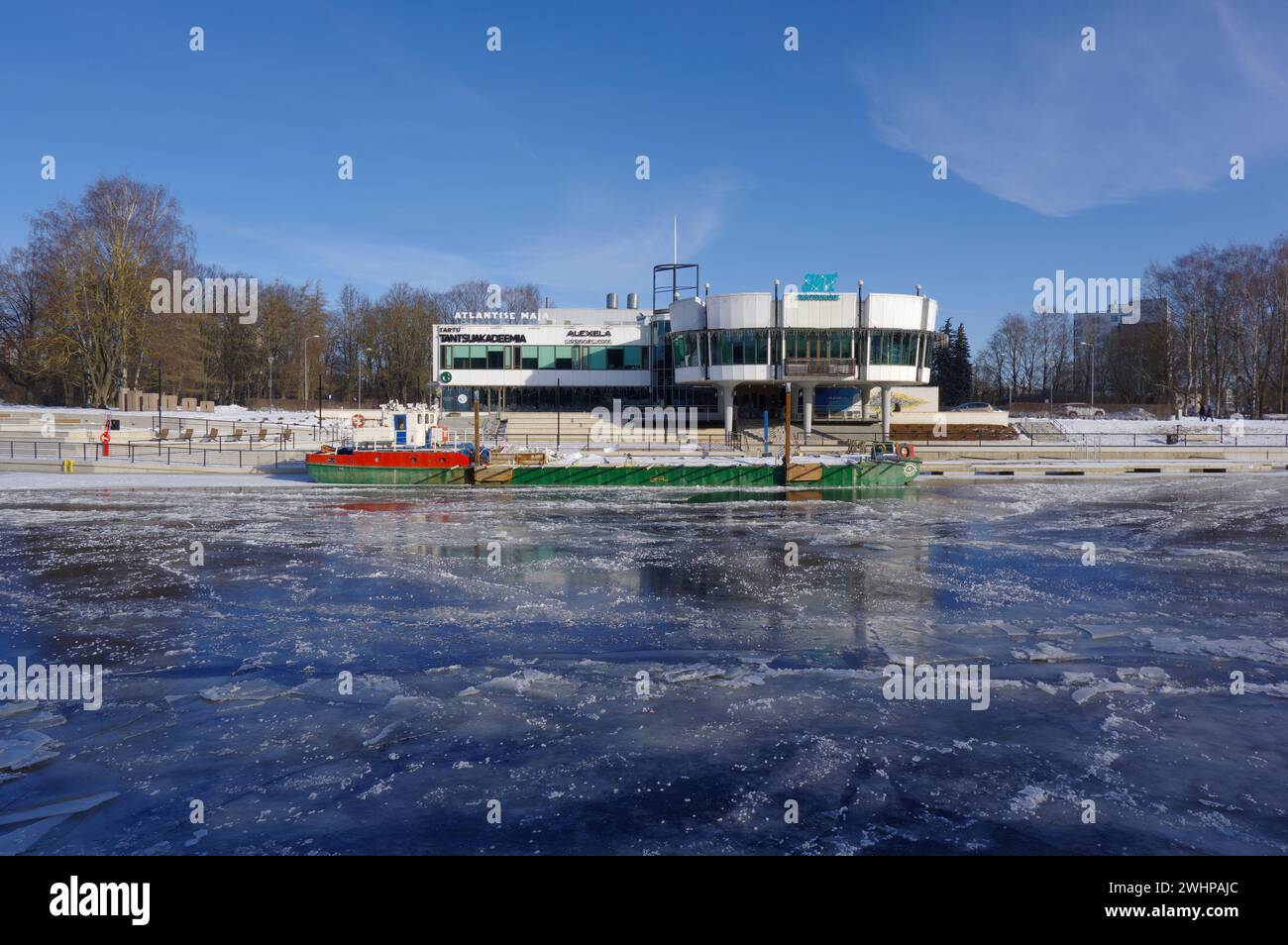 Lo storico edificio del ristorante Kaunas a Tartu, in Estonia, che oggi ospita la scuola di danza Shaté, vista dall'altra parte del fiume ghiacciato Foto Stock