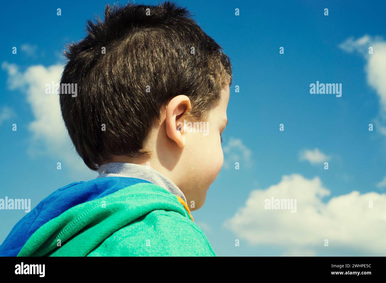 Vista posteriore della testa del bambino contro il cielo blu Foto Stock