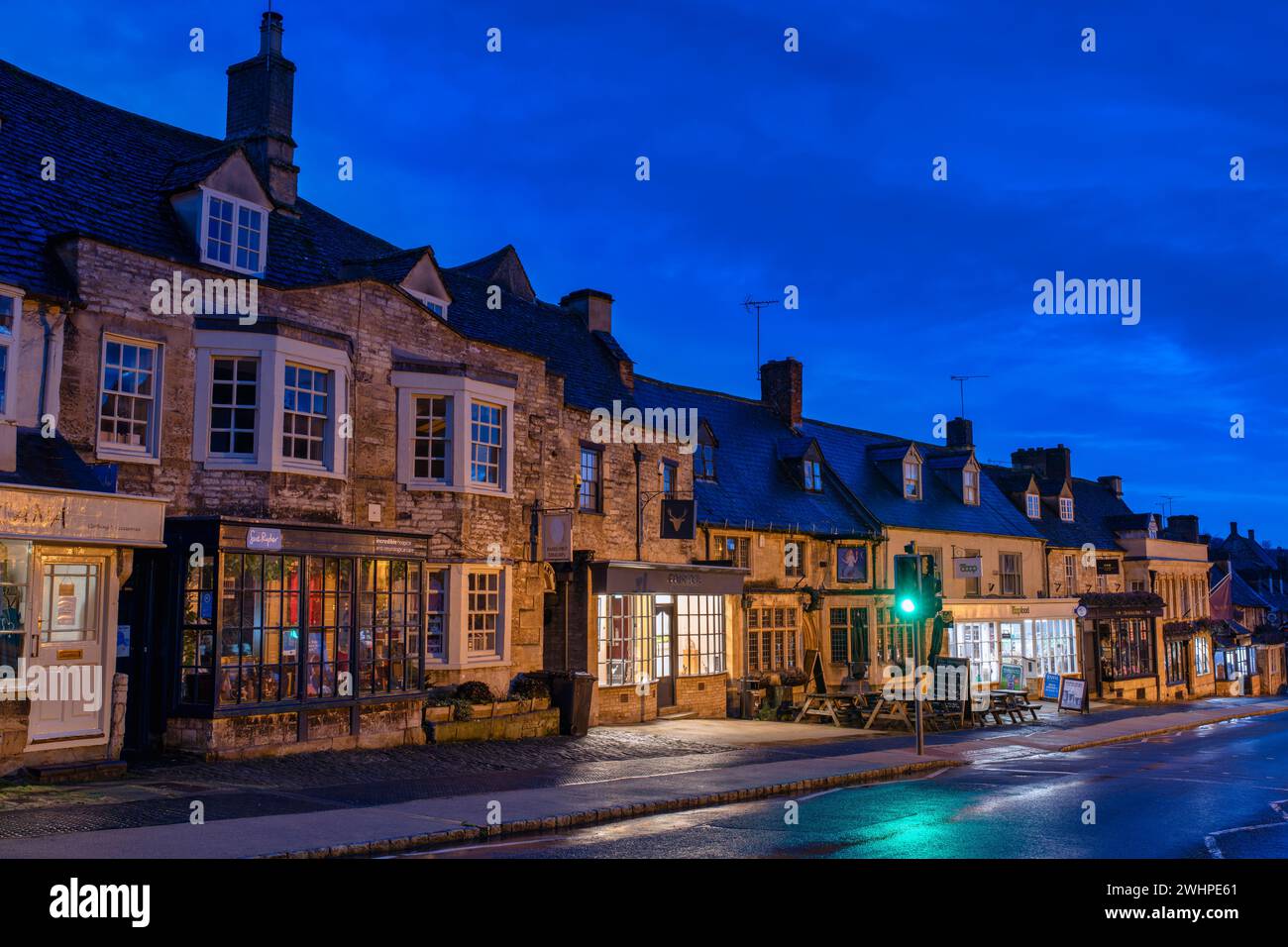 Negozi lungo la strada principale di Burford all'alba. Cotswolds, Oxfordshire, Inghilterra Foto Stock