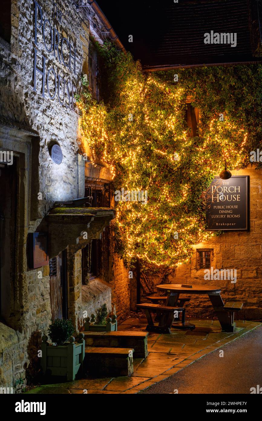 Luci gialle all'esterno del Porch House Inn di notte. Riponi sul Wold, Gloucestershire, Cotswolds, Inghilterra Foto Stock