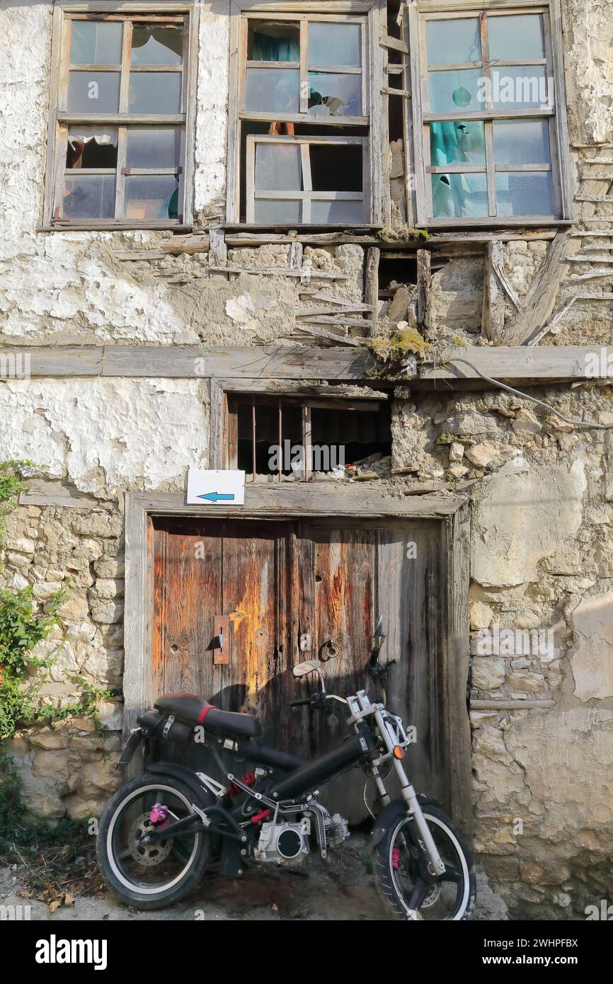328 moto Underbone alla porta scheggiata di una vecchia casa in rovina nel quartiere Varos -Olt Town. Ohrid-Macedonia del Nord. Foto Stock