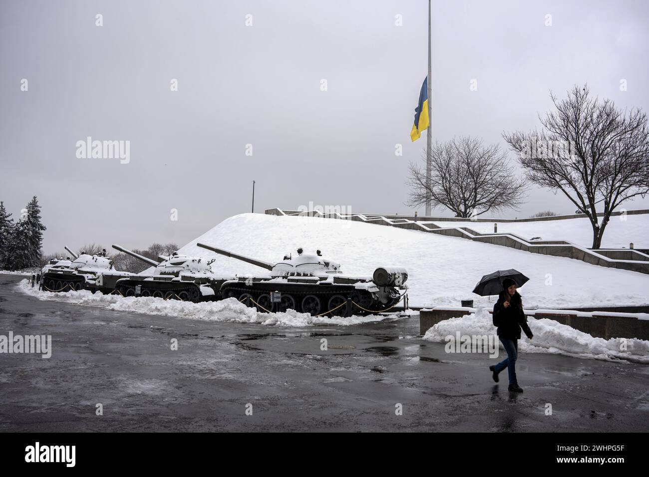 Kiev, Ucraina. 10 febbraio 2024. Una donna cammina davanti ai carri armati al complesso della Patria a Kiev. La popolazione Ucraina resiste quasi 2 anni dopo l'invasione russa su vasta scala, cercando di mantenere una vita normale. (Foto di Ximena Borrazas/SOPA Images/Sipa USA) credito: SIPA USA/Alamy Live News Foto Stock