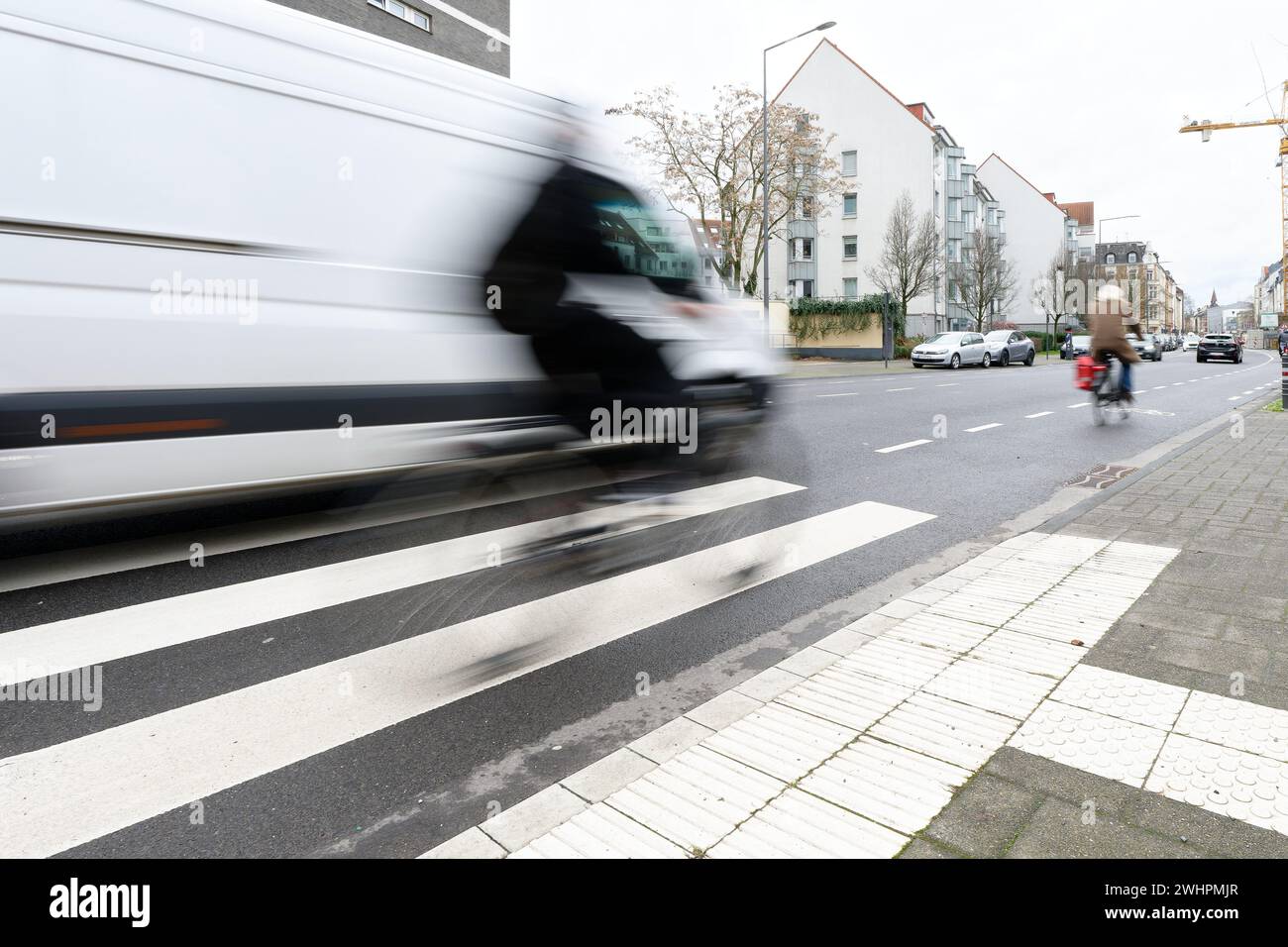 Colonia, Germania 09 febbraio 2024: I ciclisti in movimento sfocano sul vogelsangerstr a ehrenfeld vengono sorpresi da un furgone bianco mentre guidano in bicicletta Foto Stock