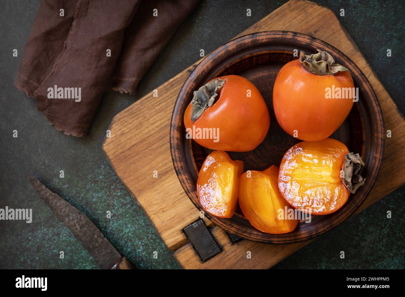 Frutta fresca biologica matura di Persimmons in una ciotola di legno. Foto Stock