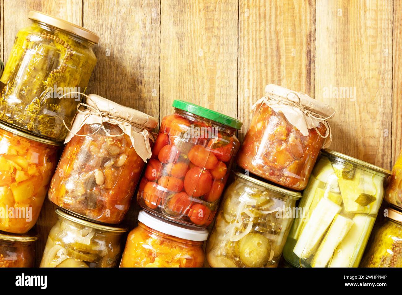 Vari tipi di verdure in scatola in vasetti di vetro su un tavolo rustico. Cibo fermentato fatto in casa sano. Economia domestica, autunno harv Foto Stock