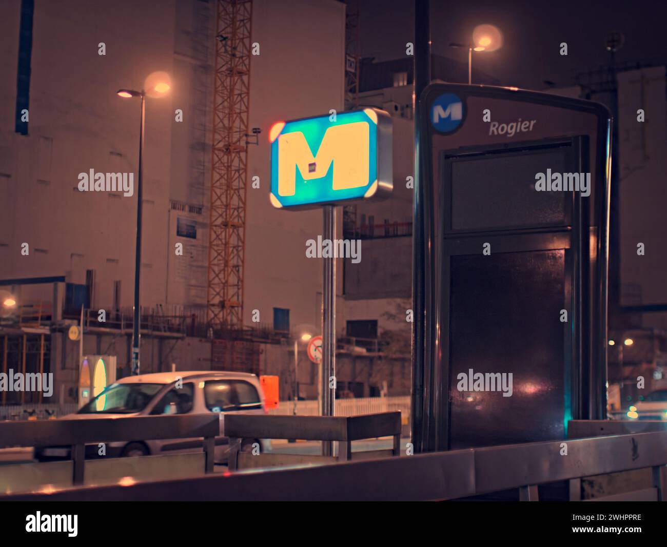 Bruxelles, Belgio. 5 febbraio 2024. Città notturna. Logo della metropolitana con la lettera M. la lettera brilla di notte. Stazione Roger. Prendi l'ascensore per la metropolitana Foto Stock