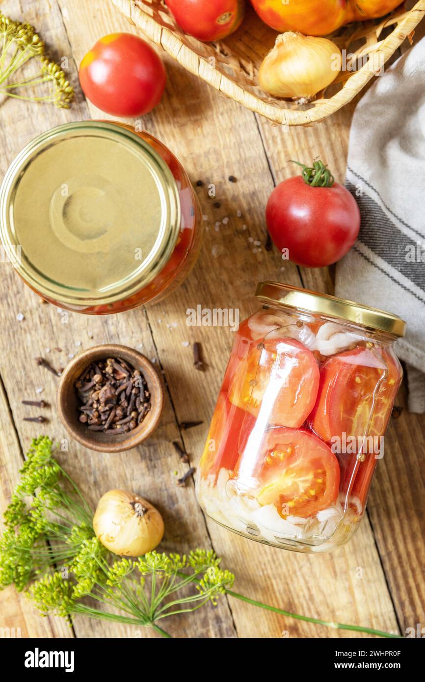 Cibo fermentato fatto in casa sano. Pomodori sottaceto salati e cipolle conservati in vasetto di vetro. Economia domestica, l'autunno dura Foto Stock