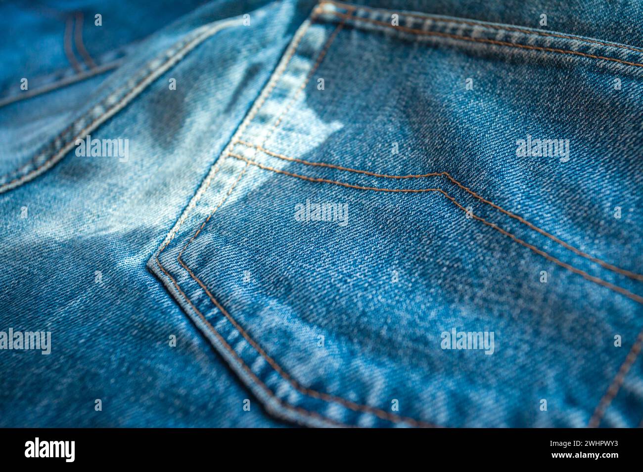 Vista della tasca posteriore dei pantaloni in denim blu e dello sfondo in tessuto Foto Stock