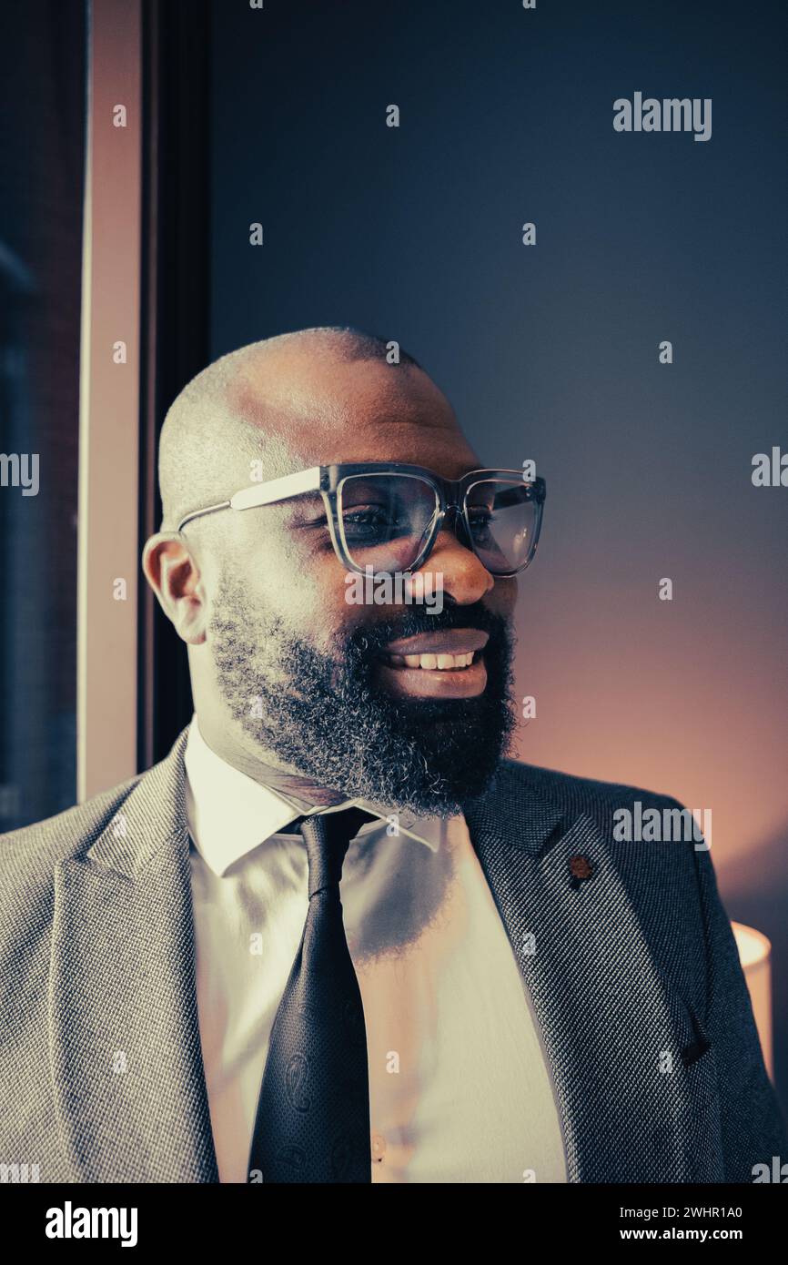 Colpo di testa di un allegro uomo d'affari afroamericano di successo dirigente elegante e leader aziendale. Allegro giovane uomo afroamericano barbuto Foto Stock