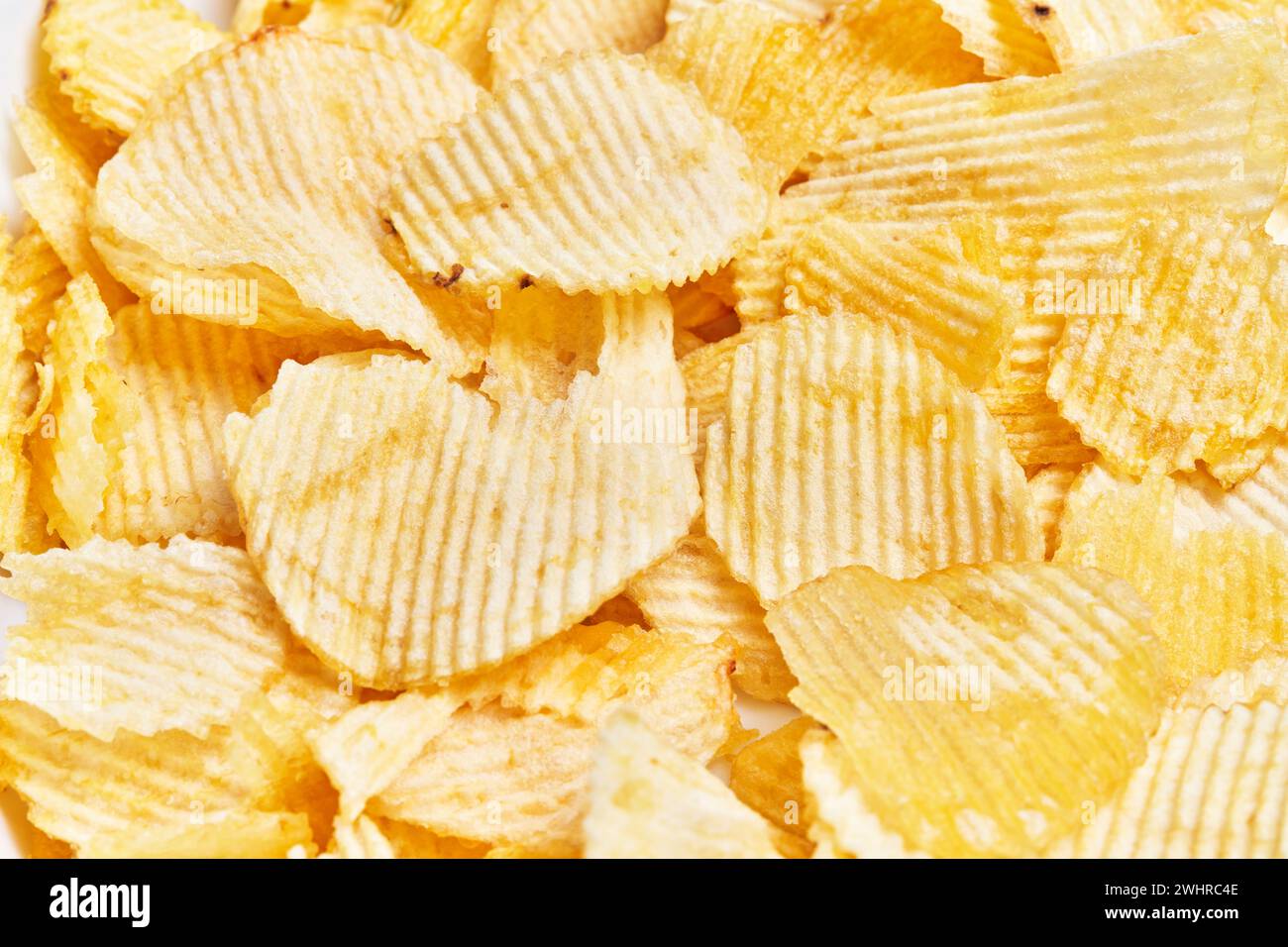 Primo piano di patatine dorate croccanti che riempiono la cornice, perfette per contenuti correlati allo spuntino. Foto Stock