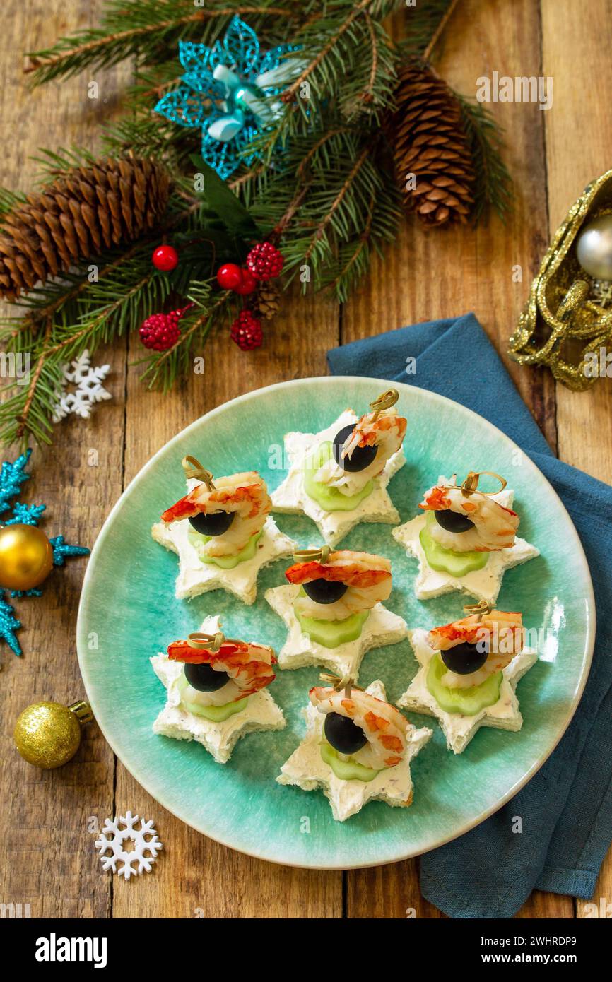Spuntino festivo di tartine sul tavolo di Natale. Tartine con formaggio, cetrioli e gamberetti. Foto Stock