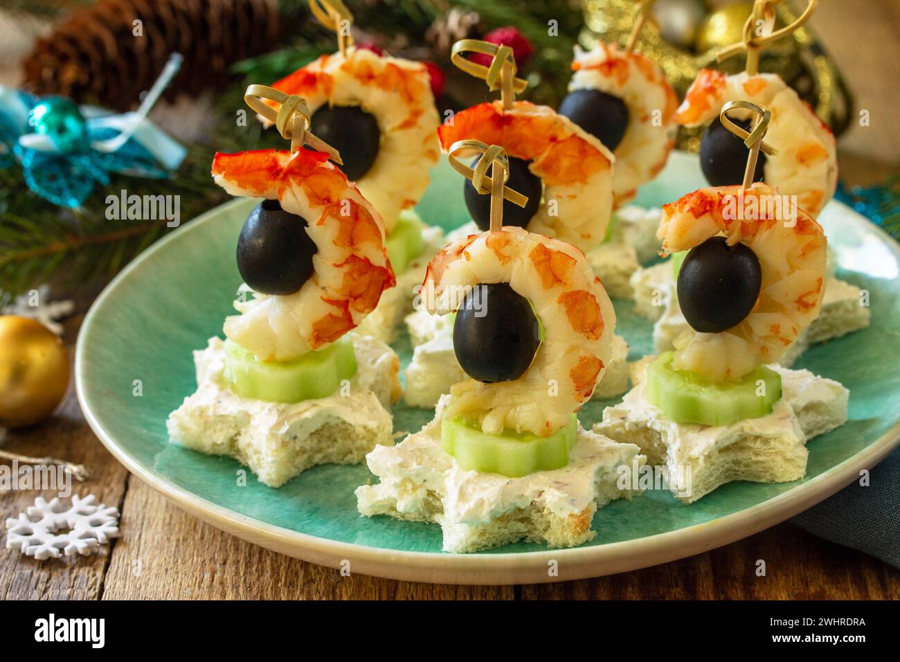 Spuntino festivo di tartine sul tavolo di Natale. Tartine con formaggio, cetrioli e gamberetti. Foto Stock