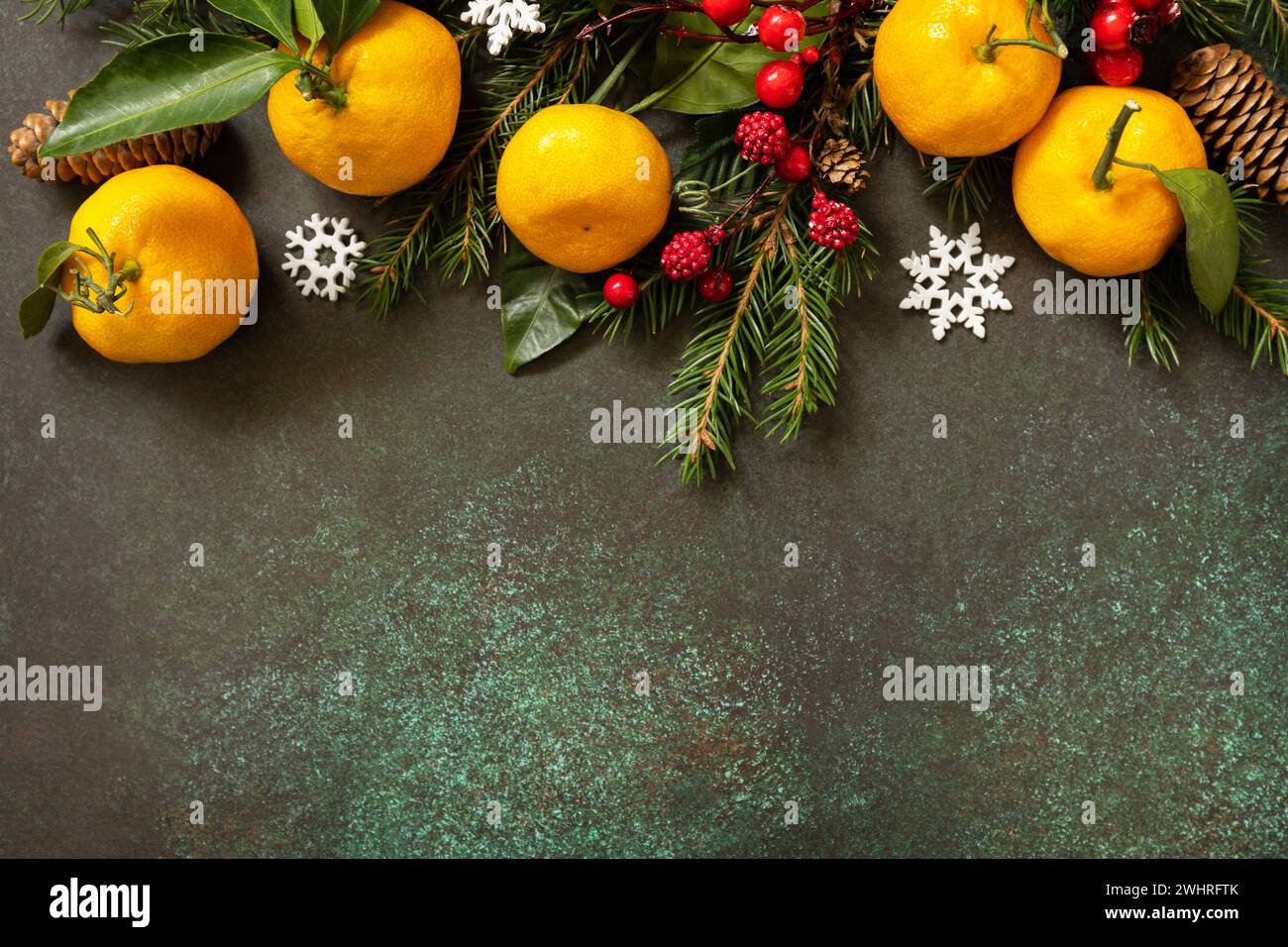 Composizione invernale con rami di abete, coni e mandarini su fondo in pietra. Biglietto di auguri Seasons. Vista dall'alto. Copia s Foto Stock