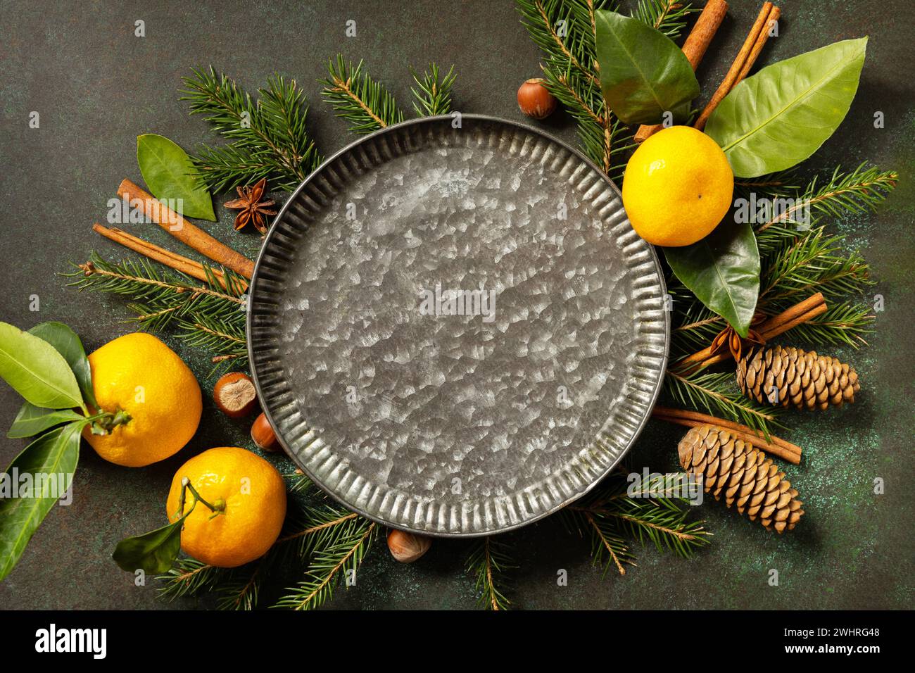 Composizione invernale con rami di abete, coni e tangerini. Atmosfera invernale accogliente. Biglietto d'auguri per le stagioni. Foto Stock