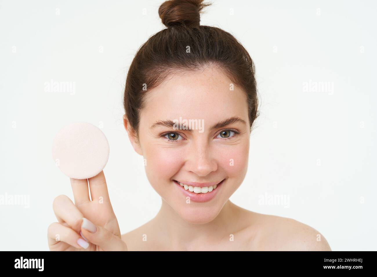 Cura della pelle e benessere. La giovane donna mostra un panno di cotone cosmetico, si toglie il trucco, usando il detergente per il viso, lavandosi il viso con l'ingegno Foto Stock