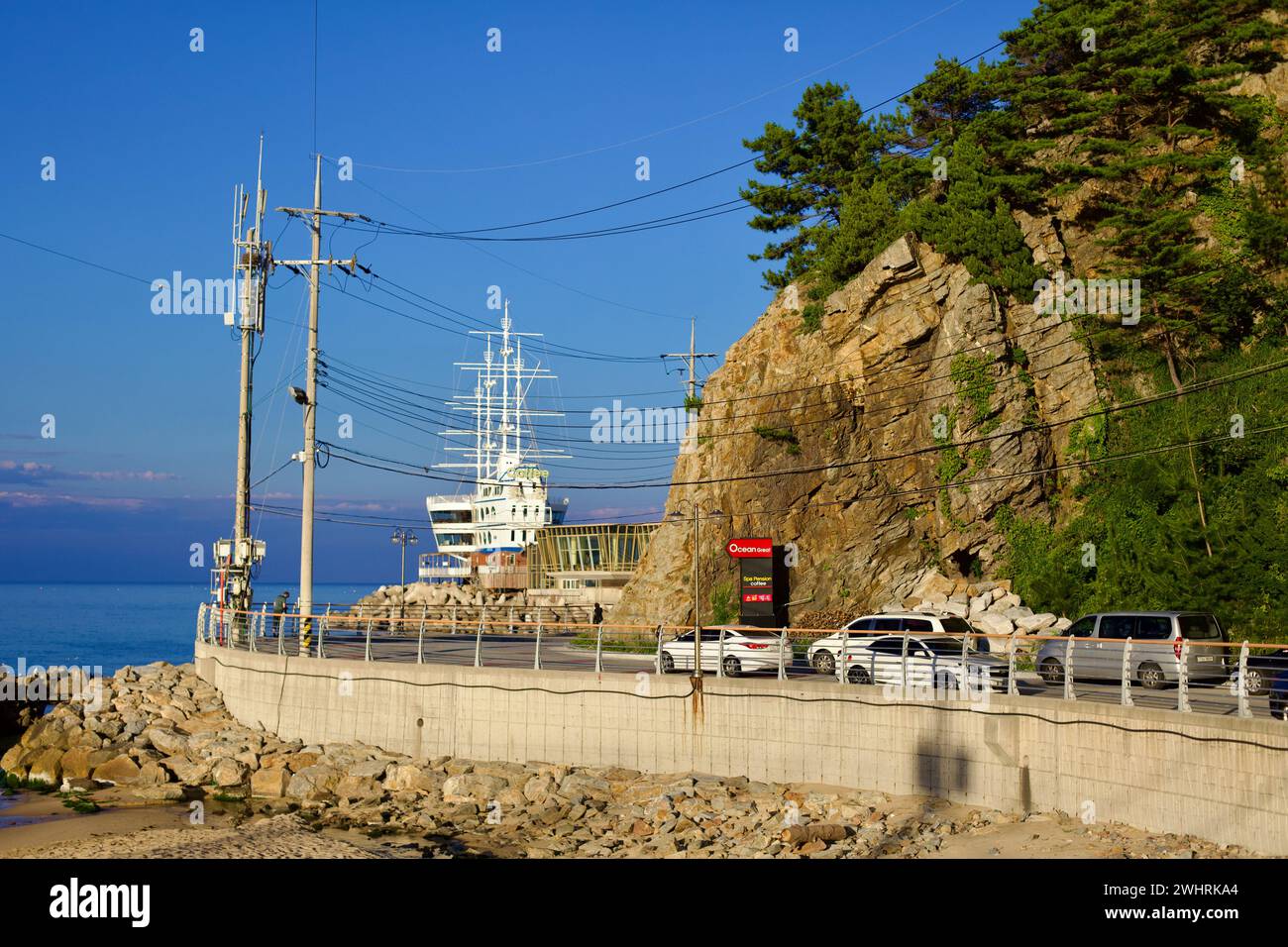 Gangneung City, Corea del Sud - 29 luglio 2019: Lungo la strada costiera vicino a Jeongdongjin, un edificio unico a forma di nave con alberi finti Foto Stock