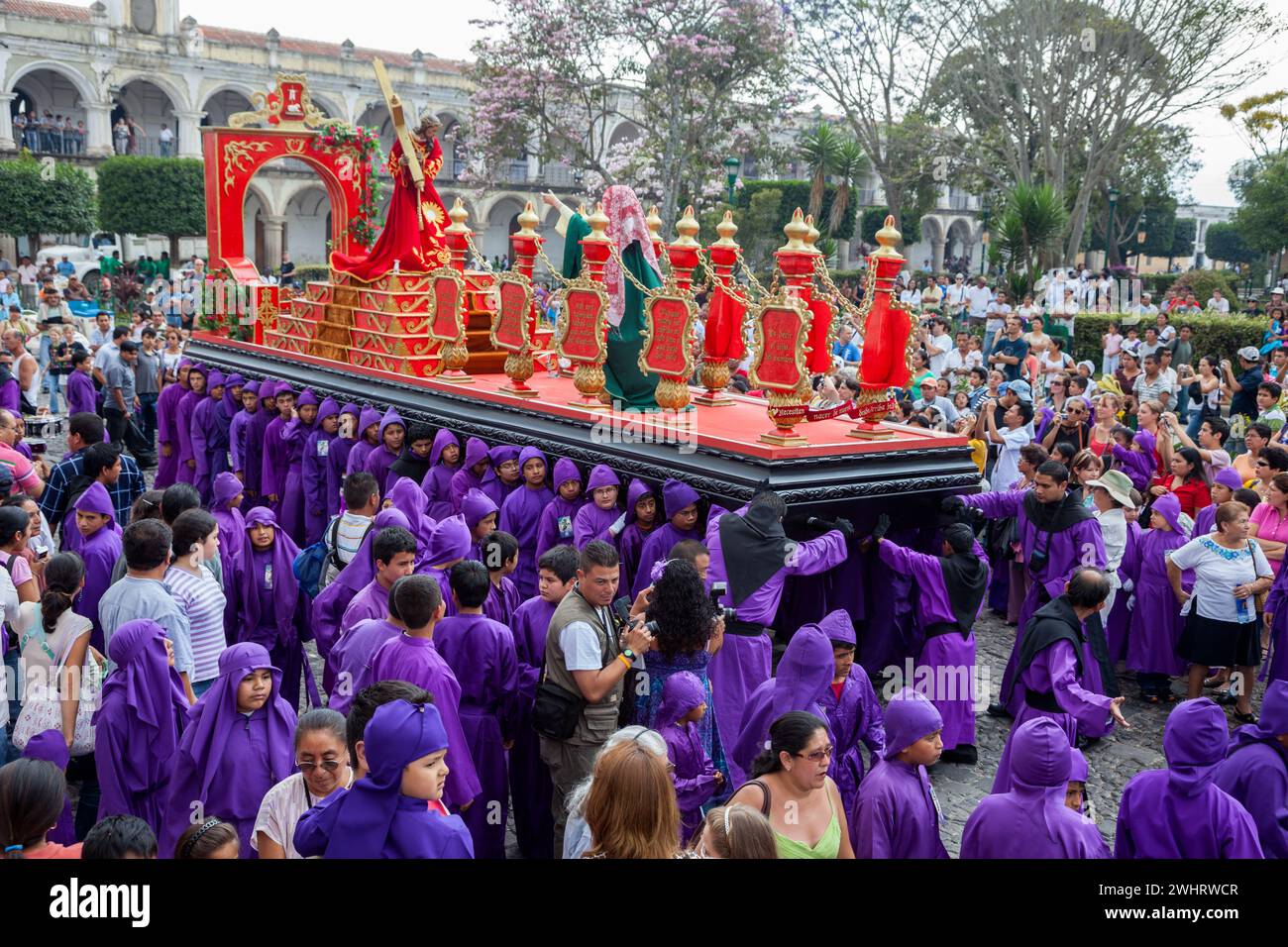 Antigua, Guatemala. I giovani Cucuruchos portano un'Anda oltre Plaza de Armas, Semana Santa. Foto Stock