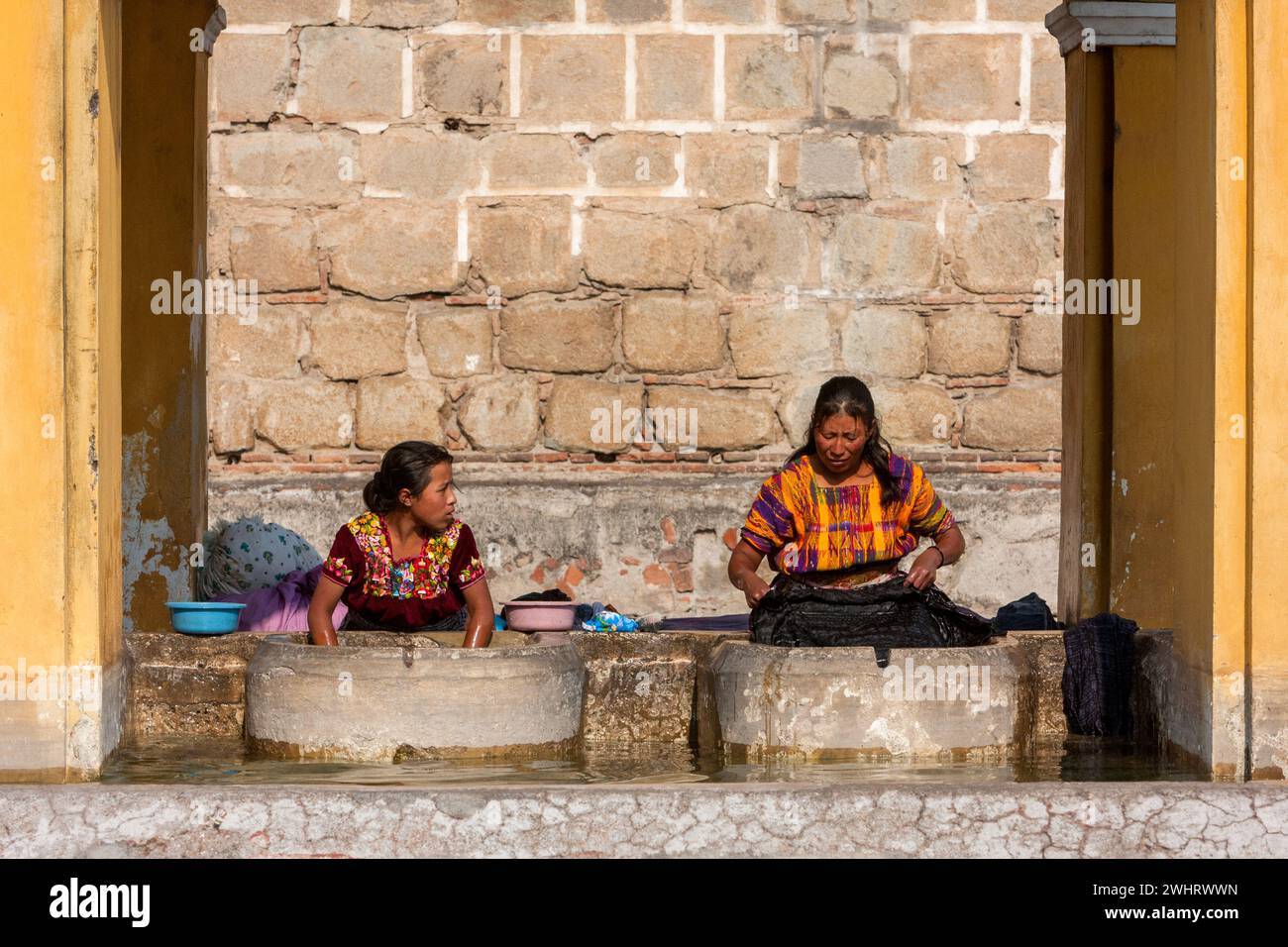 Antigua, Guatemala. Donne che fanno lavanderia al pubblico pila, o lavatrice luogo. Foto Stock