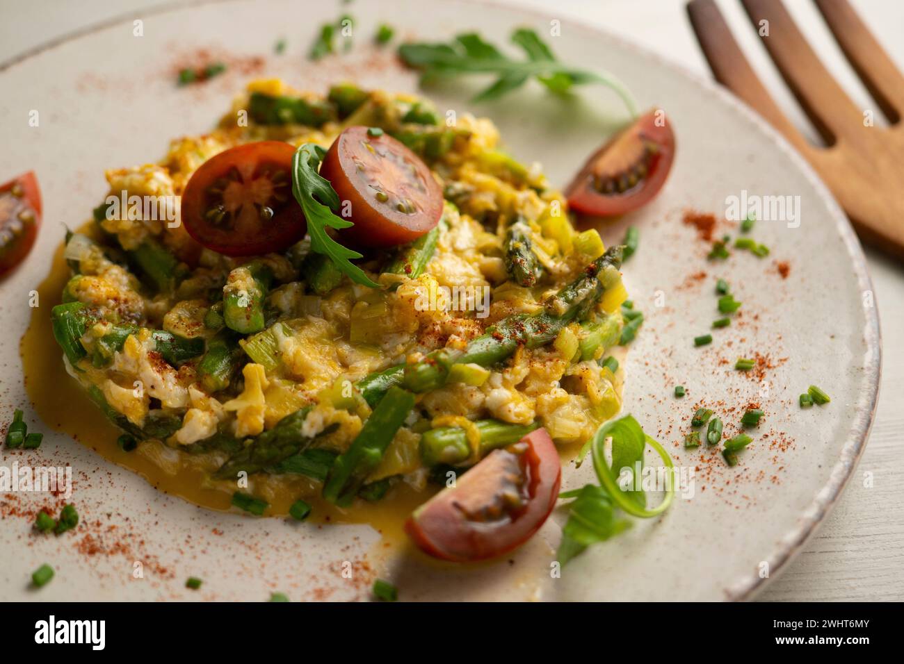 Uova strapazzate con asparagi verdi e pomodori ciliegini. Foto Stock