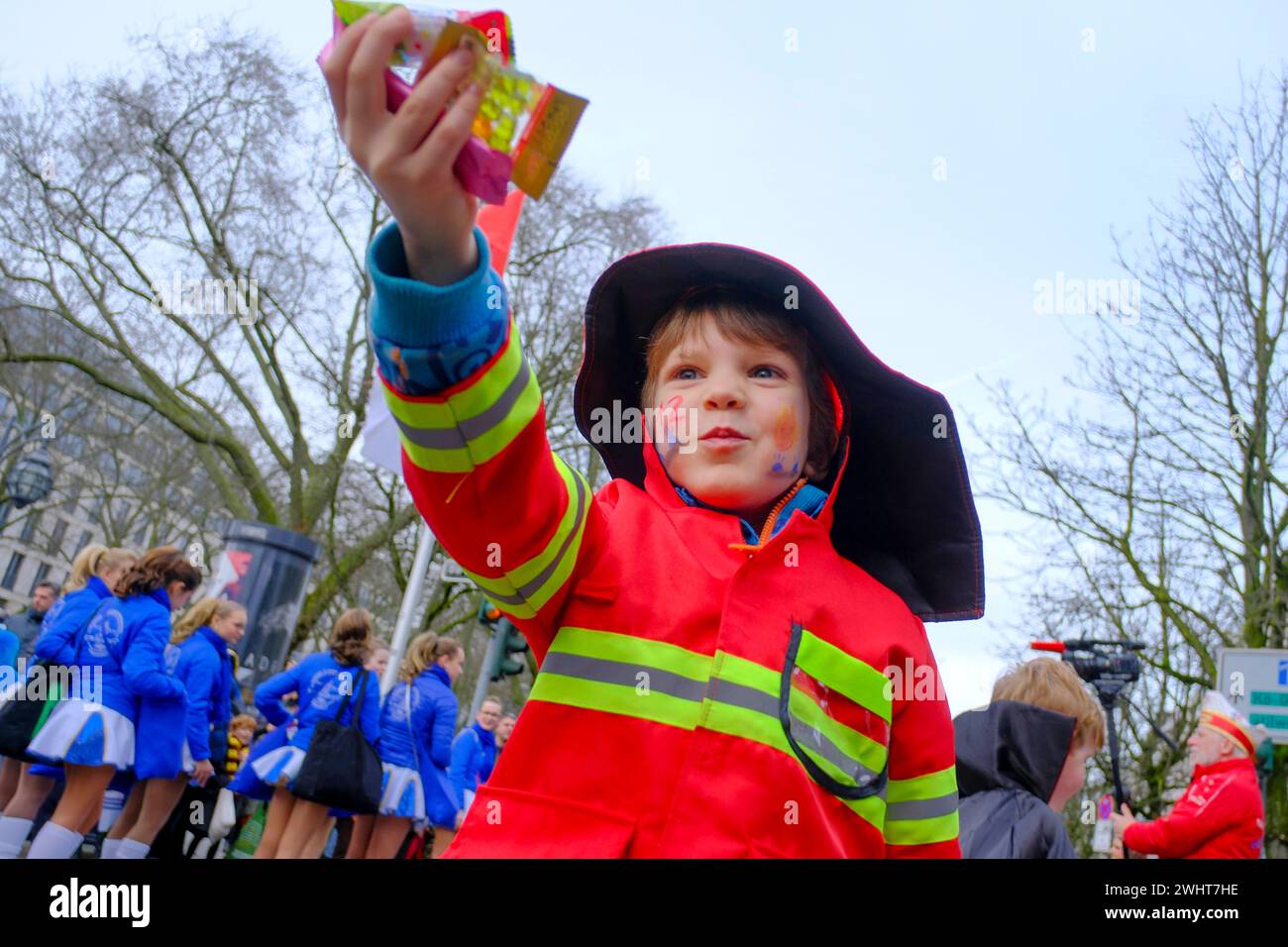 10.02.2024, Duesseldorf, Nordrhein-Westfalen, Deutschland - eine Junge, verkleidet als Feuerwehrmann, mit gesammelten Süßigkeiten beim Kinder- und Jugendumzug Düsseldorfer KITAS und Schulen im Straßenkarneval 2024 a Duesseldorf am Graf-Adolf-Platz an der Königsallee *** 10 02 2024, Duesseldorf, Renania settentrionale-Vestfalia, un pompiere vestito da vigile, Germania con dolci raccolti alla parata dei bambini e dei giovani dei centri di cura e delle scuole di Düsseldorf al carnevale di strada 2024 a Duesseldorf al Graf Adolf Platz su Königsallee Foto Stock