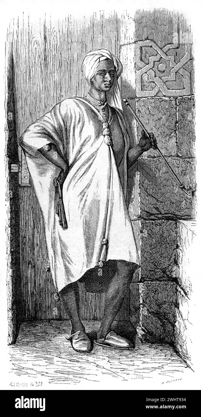 Ritratto a figura intera di un uomo nubiano che indossa abiti tradizionali o abiti etnici, tra cui una tunica lunga nota come Gallabya e un velo da uomo, o Ghuthra, Nubia, Egitto meridionale e Sudan settentrionale, Africa. Incisione vintage o storica o illustrazione 1863 Foto Stock