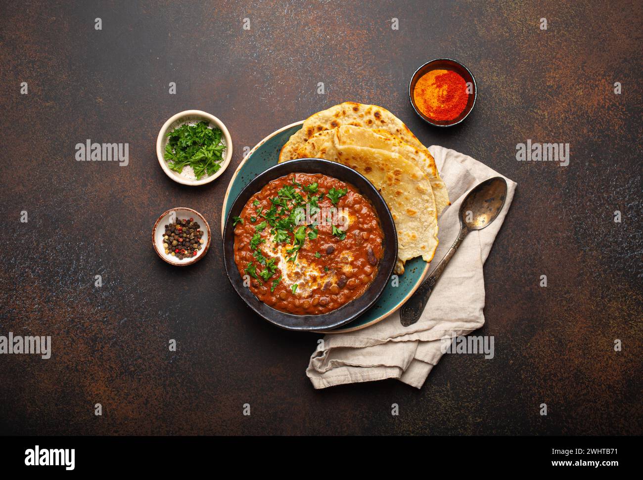 Tradizionale piatto punjabi indiano dal makhani con lenticchie e fagioli in ciotola nera servito con pane piatto naan, coriandolo fresco e. Foto Stock