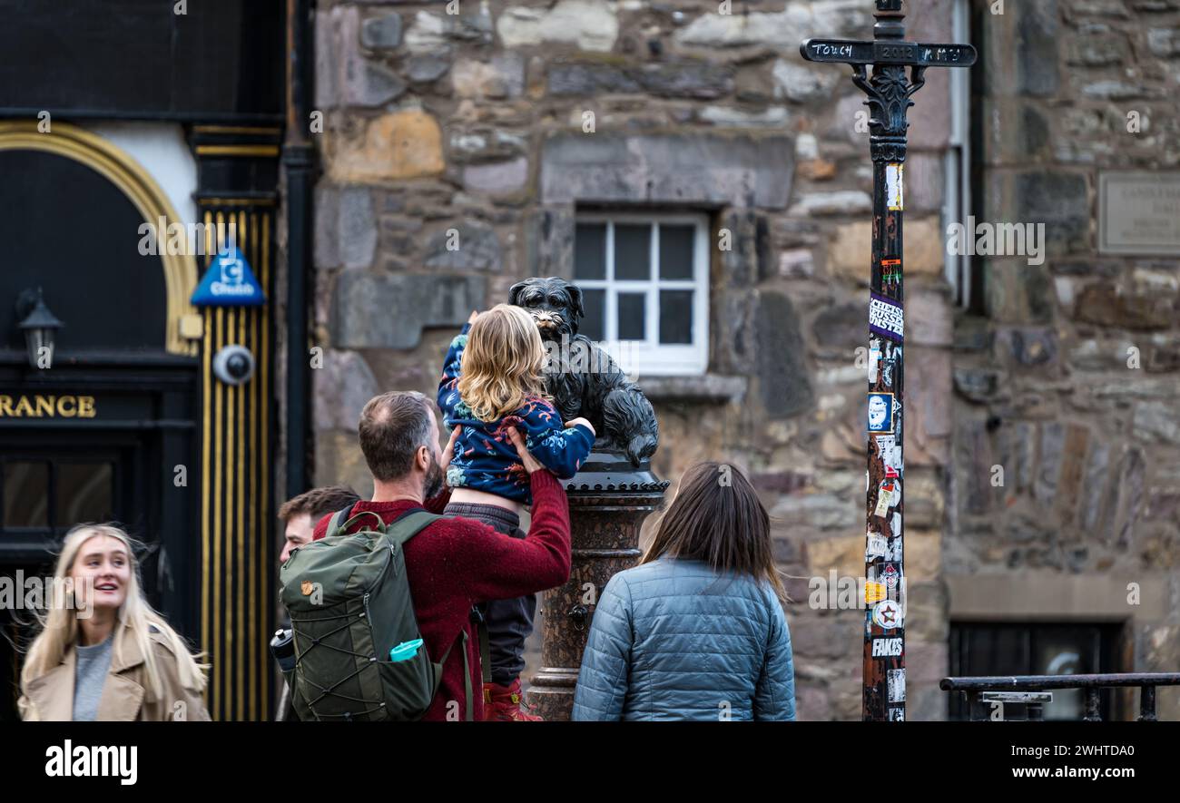 Turista toccante naso della statua del cane Bobby di Greyfriar per buona fortuna, Edimburgo, Scozia, Regno Unito Foto Stock