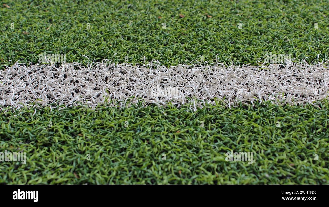 La linea di demarcazione del campo sportivo con una foto dettagliata del tappeto erboso artificiale Foto Stock