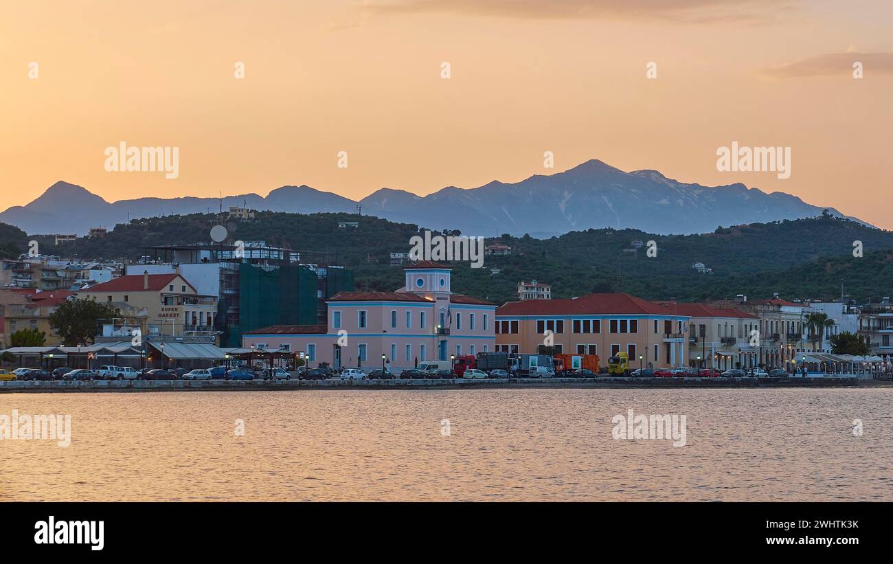Costa con edifici e montagne durante un tramonto colorato, monti Taygetos innevati, Taygetos, Gythio, mani, Peloponneso, Grecia Foto Stock