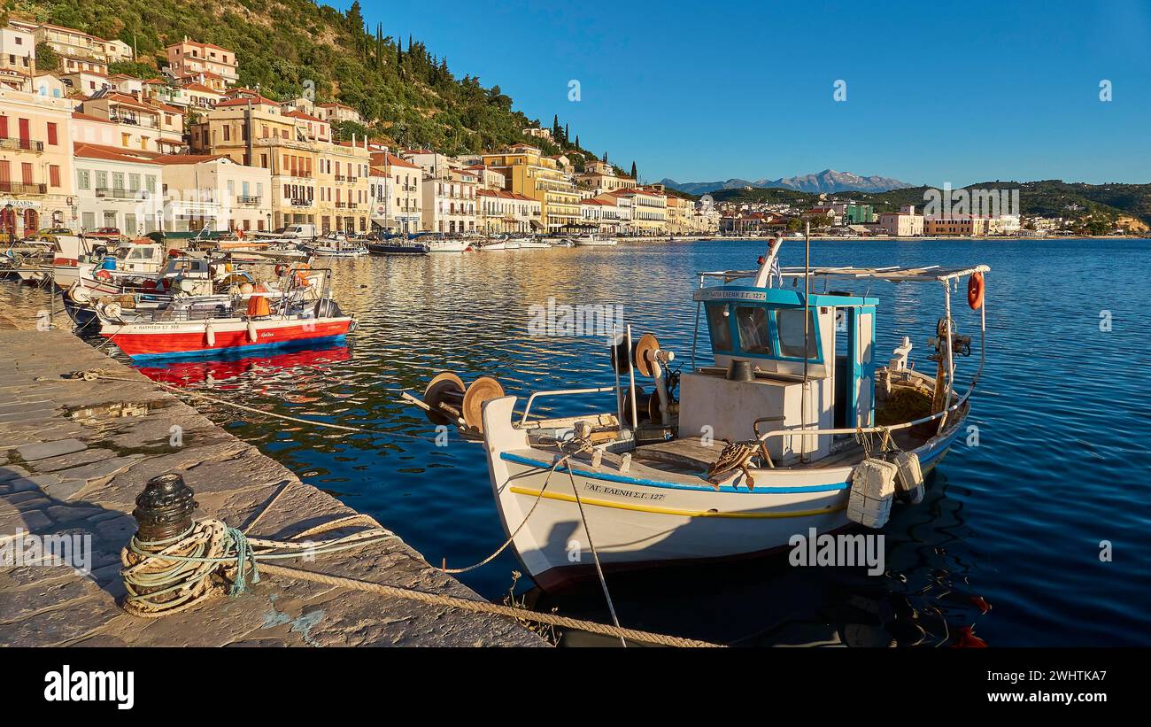 Porto tranquillo con barche di fronte alla pittoresca cittadina costiera e montagne sullo sfondo, i monti Taygetos, Taygetos, Gythio, mani Foto Stock