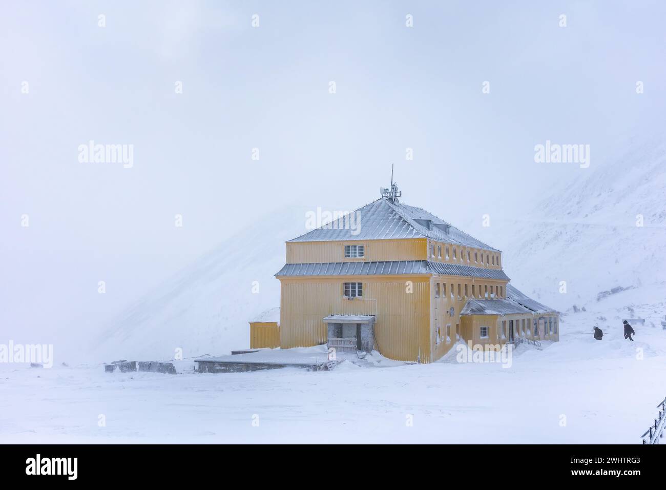 Il rifugio sul monte Dom Slaski si affaccia sul monte Sniezka. Condizioni climatiche difficili in montagna. Edifici ricoperti di ghiaccio. Foto scattata in un inverno nuvoloso Foto Stock