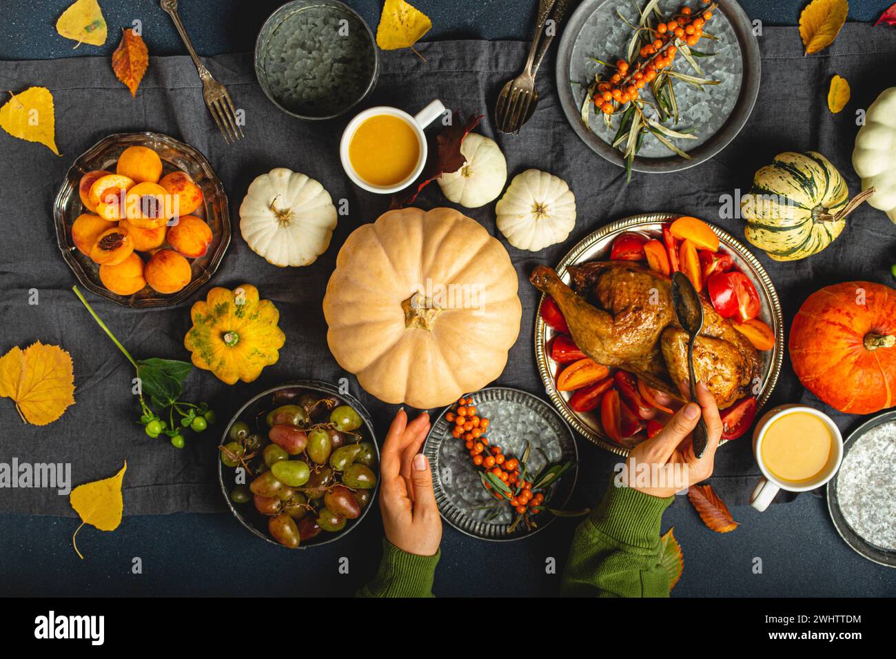 Composizione tavola festiva del Ringraziamento con tacchino arrosto, zucche, insalata di verdure, frutta, bevanda all'arancia. Cele del Ringraziamento Foto Stock